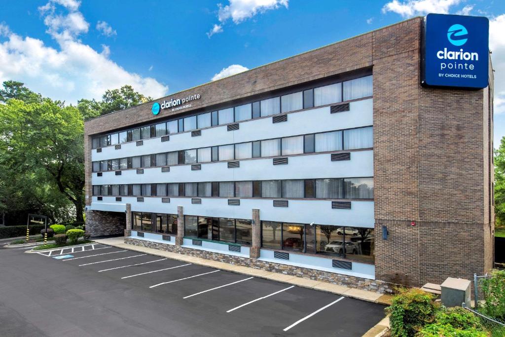 Un edificio con un estacionamiento enfrente. en Clarion Pointe Raleigh Midtown, en Raleigh