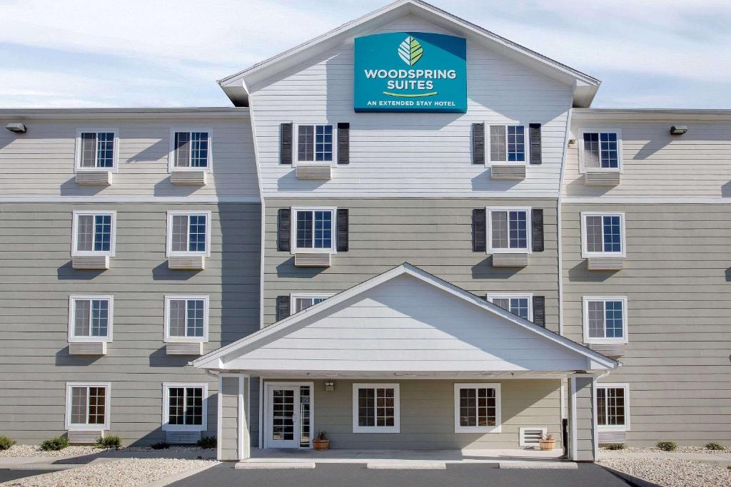 a building with a sign that reads woodworking sites at WoodSpring Suites Richmond Colonial Heights Fort Gregg-Adams in Colonial Heights