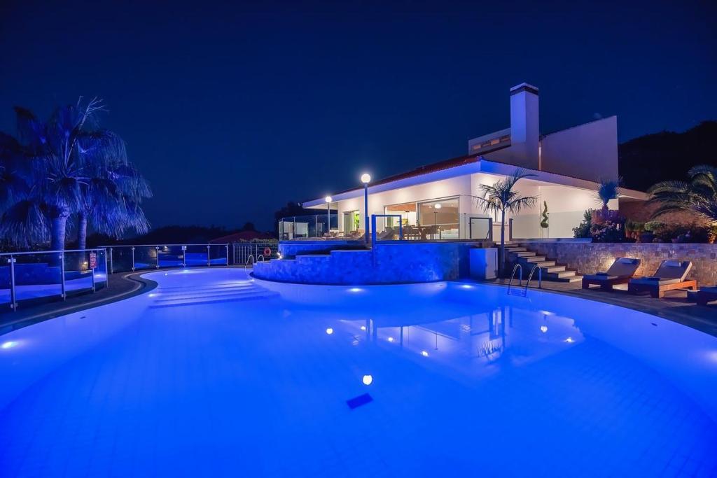 a swimming pool in front of a house at night at Giakoumakis Luxury-Private Villa in Xirón Khoríon