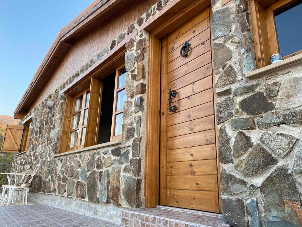 drewniane drzwi na boku kamiennego budynku w obiekcie Aretis sea view house w mieście Pachyammos