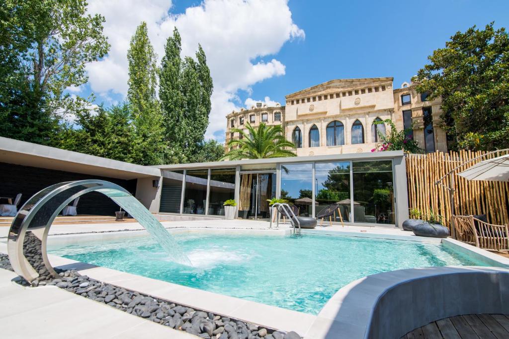 a swimming pool with a fountain in front of a building at Mikelina Boutique Hotel in Pallíni