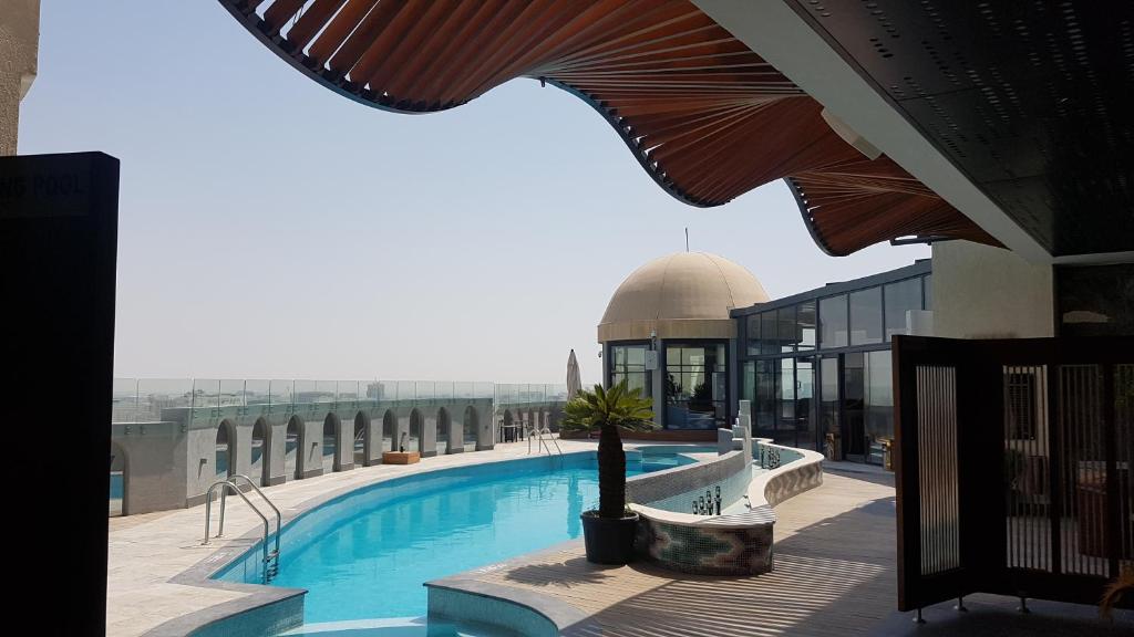 una piscina sul tetto di un edificio con una moschea di Horizon Manor Hotel a Doha