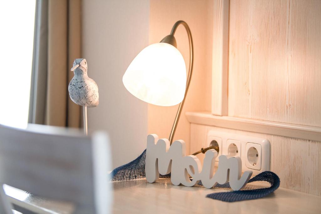 una mesa con una lámpara y una señal que diga mamá en Alter Landkrug, en Nortorf