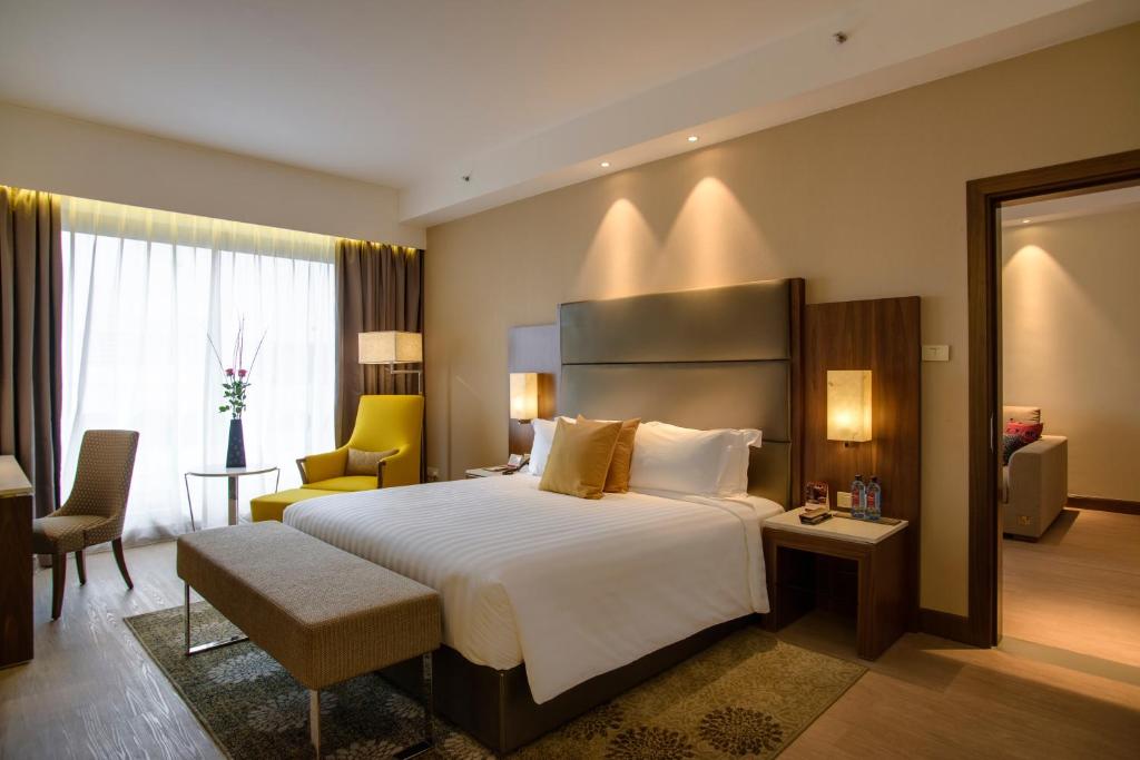 a hotel room with a bed and a chair at Crowne Plaza Nairobi Airport by IHG in Nairobi