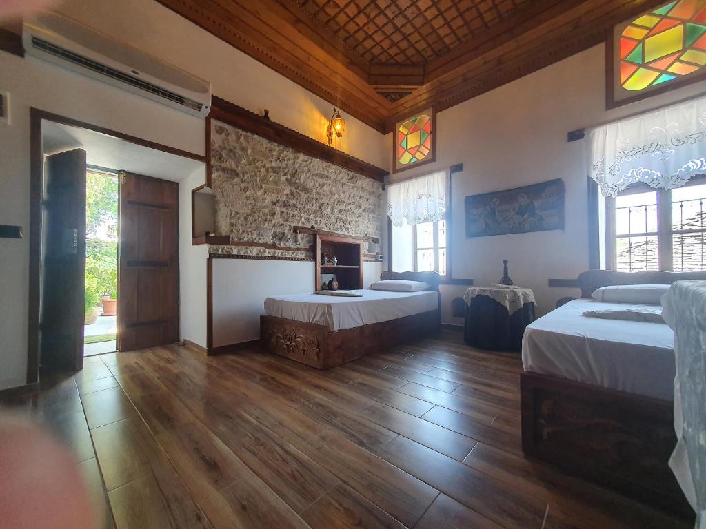 a large room with two beds and a fireplace at RIVA Guest House in Gjirokastër