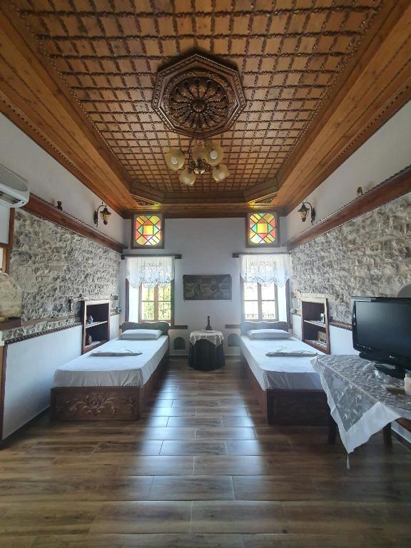 pokój z czterema łóżkami i telewizorem w obiekcie RIVA Guest House w Gjirokastrze