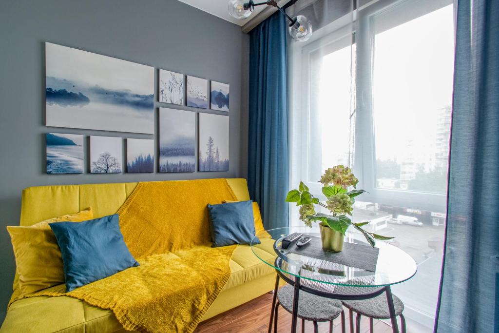 a living room with a yellow couch and a table at Cozy House 128A in Moscow