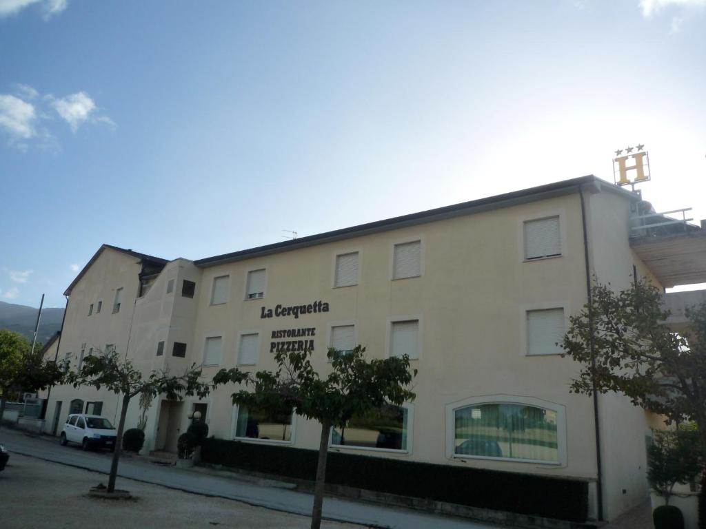 un edificio blanco con un cartel en el costado en La Cerquetta, en Trevi