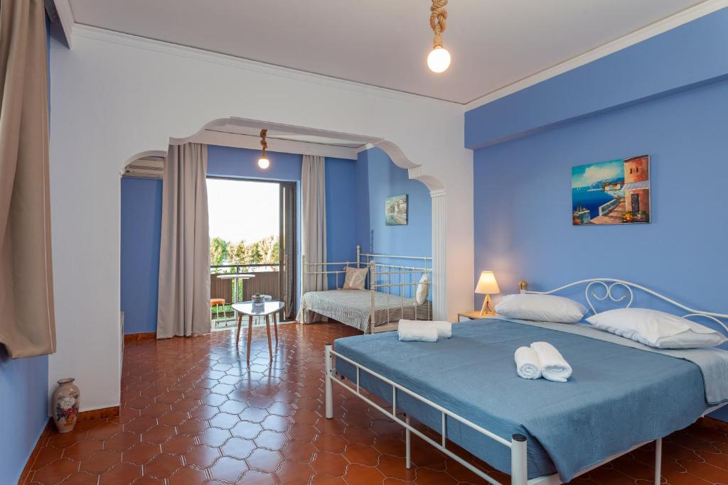 1 dormitorio azul con 1 cama y 1 silla en CHAMBRE BLEUE en Ialyssos