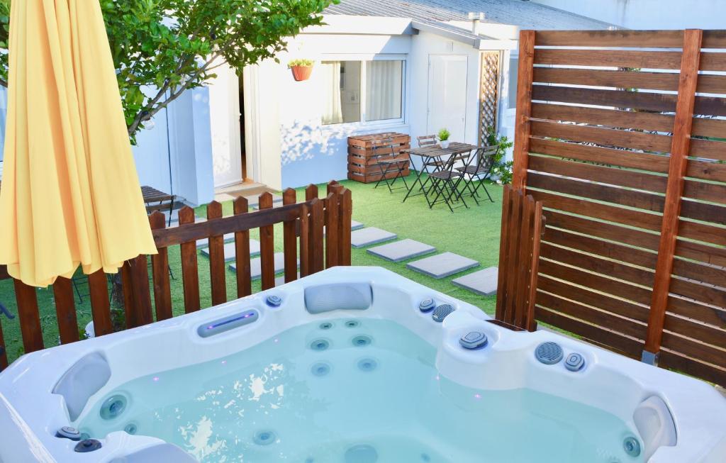 a hot tub on a backyard with a fence at Porto Garden Villas | Downtown in Vila Nova de Gaia