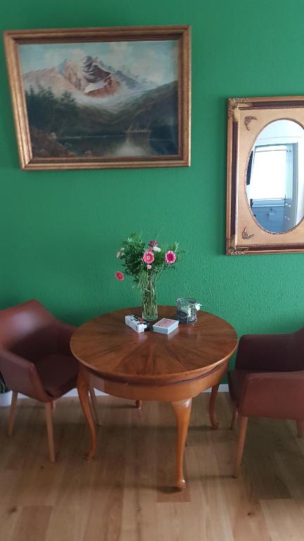 a wooden table with a vase of flowers on it at Malvelyns am Bodensee in Immenstaad am Bodensee