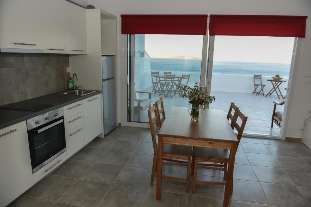 a kitchen with a table and a view of the ocean at Splendide Apartments in Agios Nikolaos
