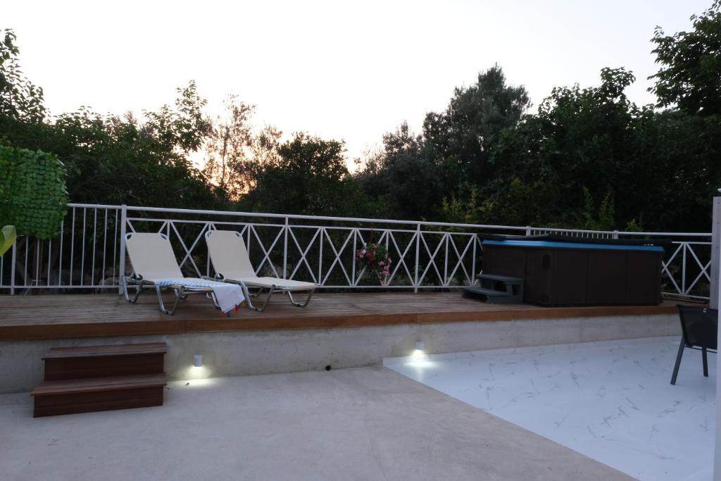 two white chairs and a grill on a patio at Luxury Fani House Next to Harbor area with Jacuzzi in Paphos