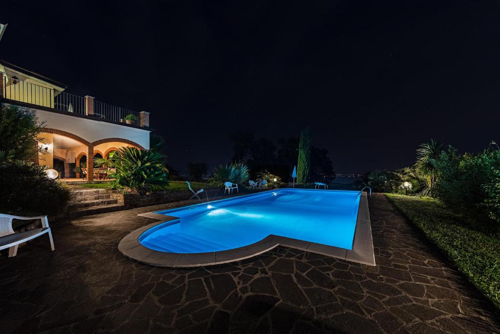 una grande piscina blu in un cortile di notte di Daller Bianca Apartment by Wonderful Italy a Soiano del Lago