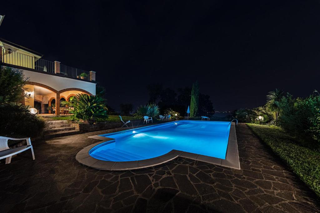 a large blue swimming pool in a yard at night at Daller Bianca Apartment by Wonderful Italy in Soiano del Lago