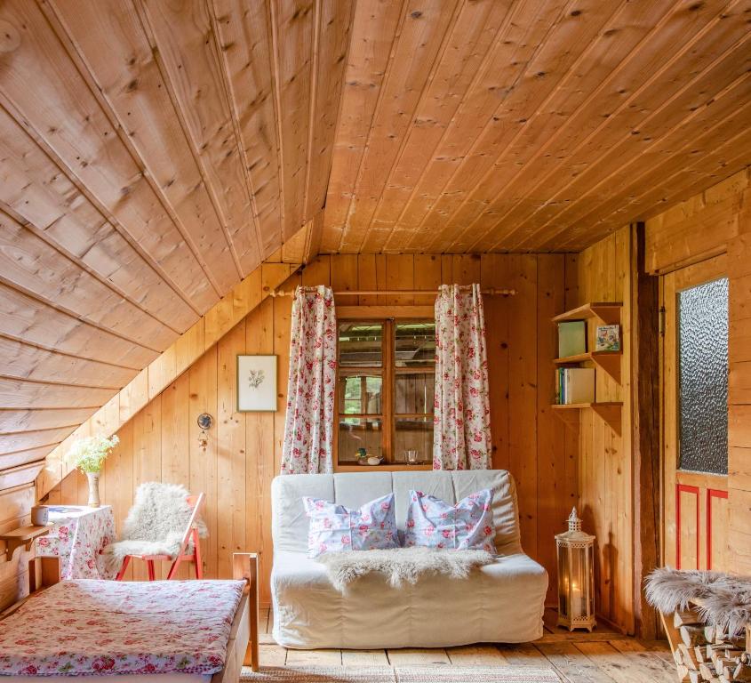 ein Wohnzimmer mit einer weißen Couch in einem Holzzimmer in der Unterkunft Unplugged Almhütte Waldbauer in Reichenfels