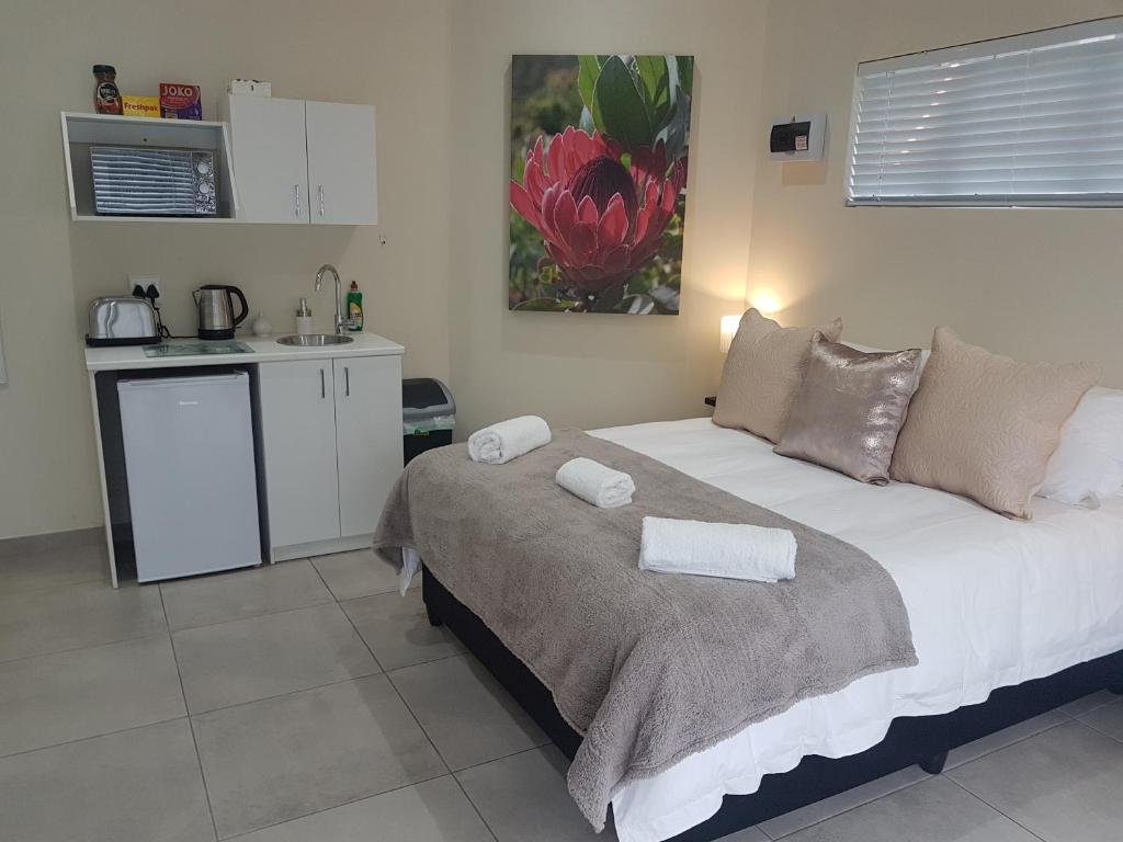 a bedroom with a bed with two towels on it at Sharon's House: Modern Self-Catering rooms in Cape Town