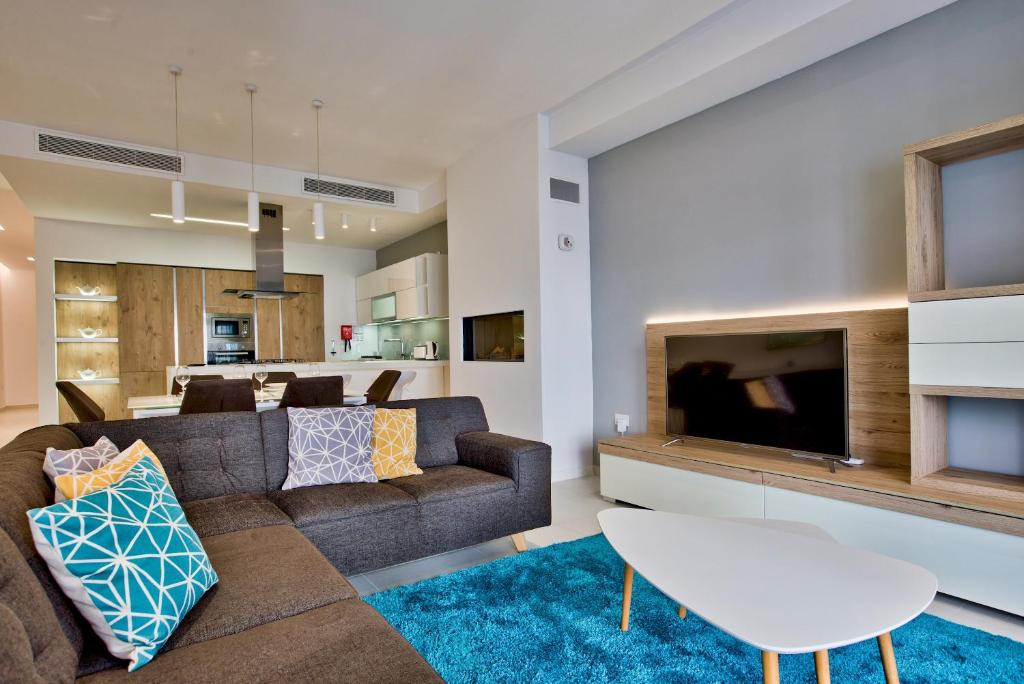 - un salon avec un canapé et une télévision dans l'établissement Bright & Spacious 3 Bedroom Apartment in Mellieha, à Mellieħa