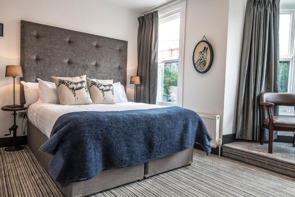 a bedroom with a large bed with a blue blanket at Sinclair's Rooms in Southport