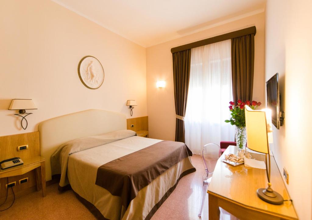 Habitación de hotel con cama y ventana en Albergo Russo, en Trapani
