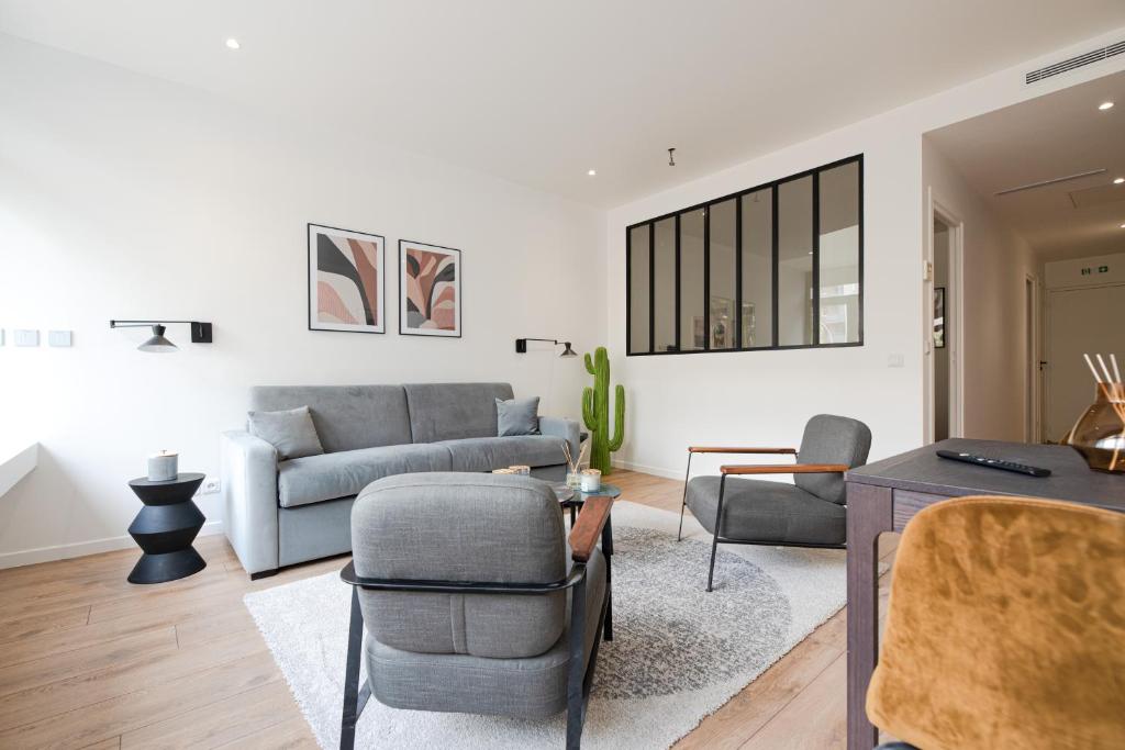 een woonkamer met een bank en een tafel bij Luxury Residence - Paris South in Montrouge