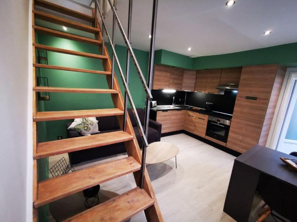 une cuisine avec un escalier en colimaçon dans une pièce dans l'établissement Au numéro 2 Le Zen, à Châteauroux