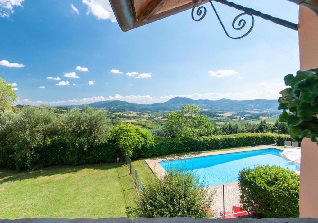 a villa with a swimming pool and mountains in the background at Agriturismo Il Poggio, Casa Rosa in Umbertide
