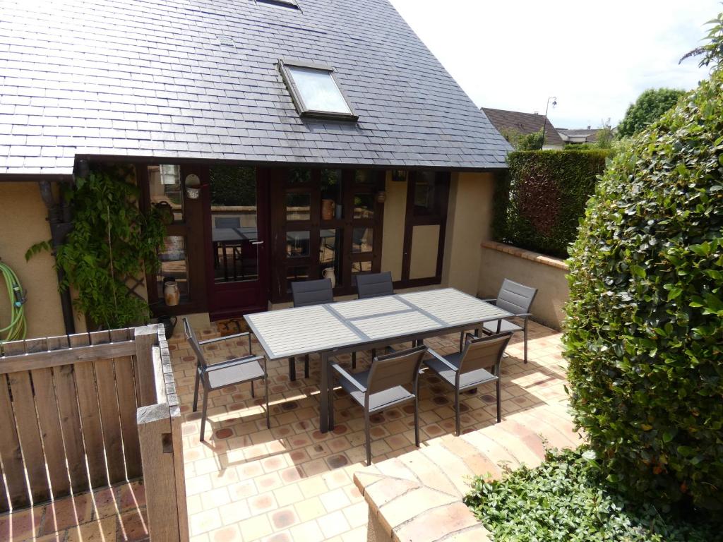 einen Tisch und Stühle auf einer Terrasse mit einem Haus in der Unterkunft Gite Des Vignes in Verdigny