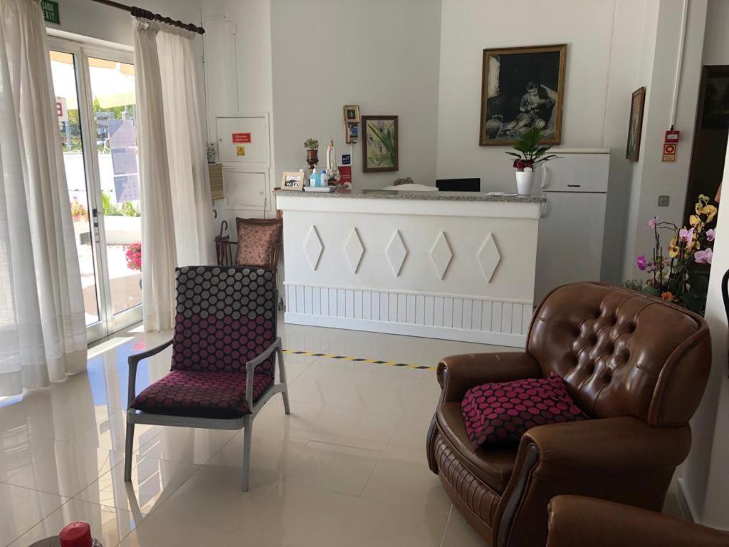 sala de estar con 2 sillas y chimenea en Residencia Maria Jose, en Fátima