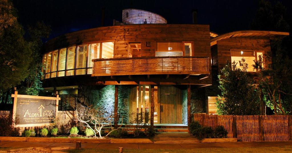 a large wooden building at night at Aldea Naukana Posada Boutique in Pucón