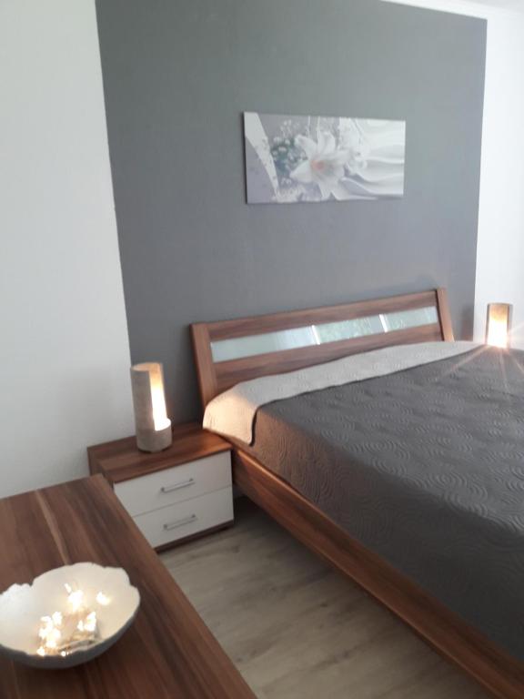 1 dormitorio con cama y mesa de madera en Ferienwohnung an der Klinge, en Aalen
