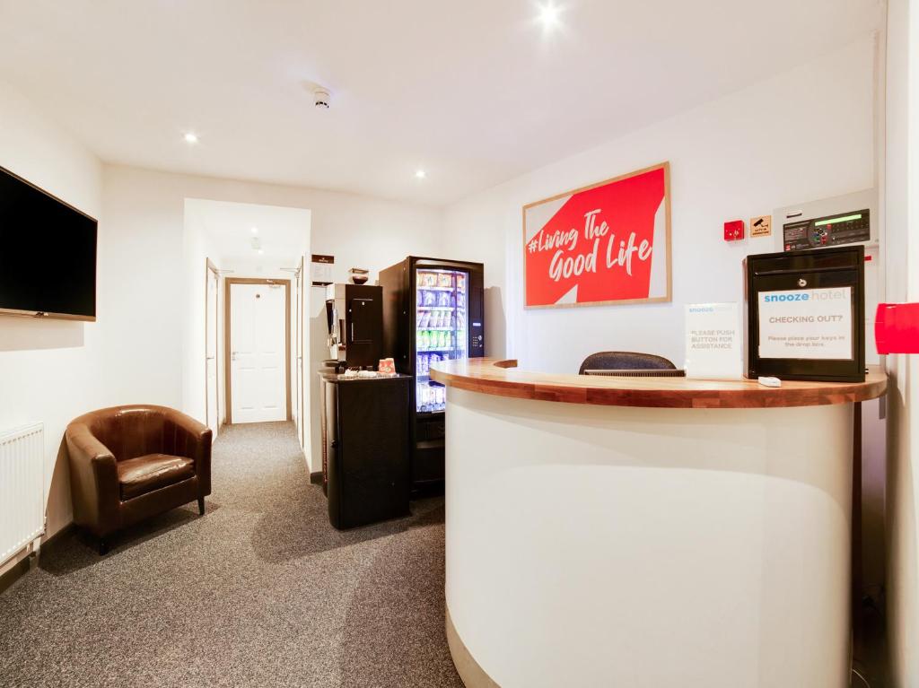 a bar in a room with a counter and a chair at Snooze Hotel in Corby