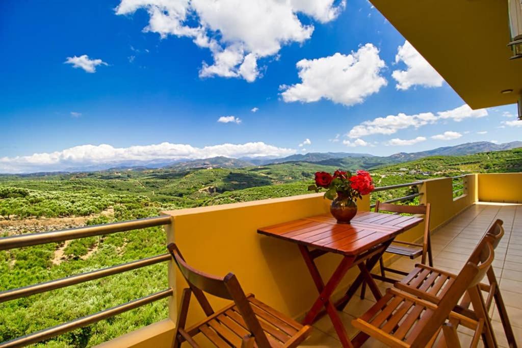 einen Tisch und Stühle auf einem Balkon mit Aussicht in der Unterkunft Mantarini House in Áyios Andónios