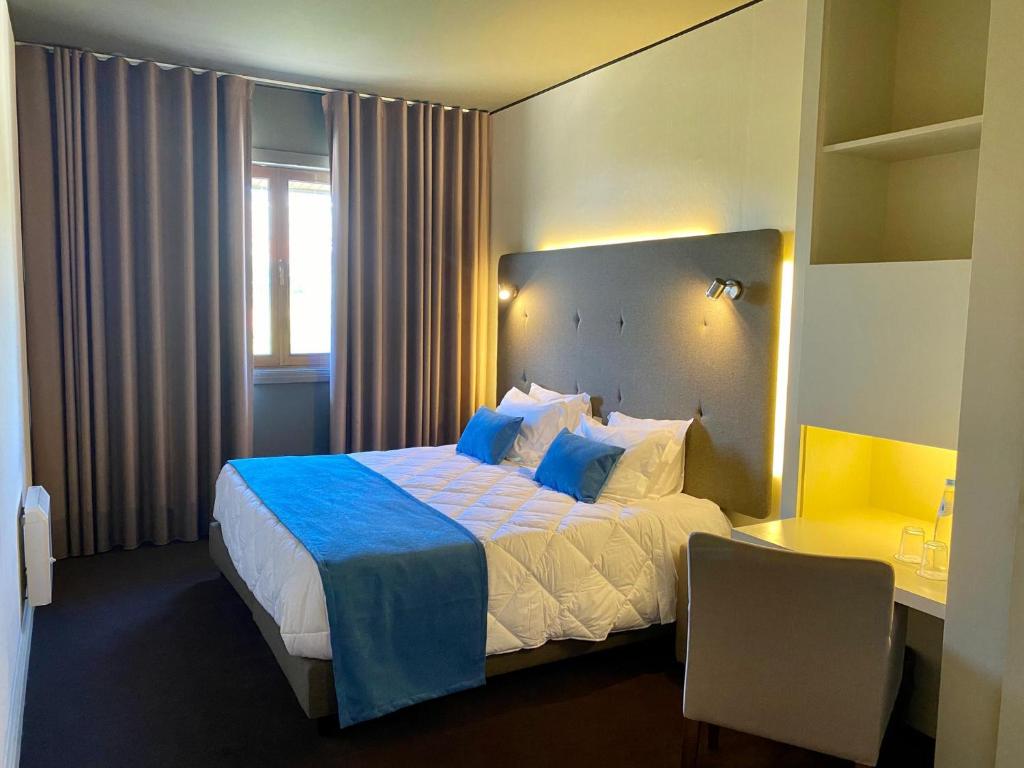 a hotel room with a large bed and a desk at Vilar Oporto Hotel in Porto