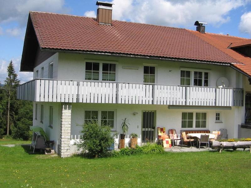 una gran casa blanca con techo rojo en Ferienwohnung Dreiländereck, en Haidmühle