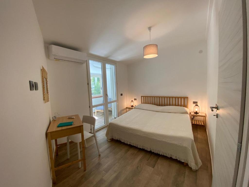 モンデッロにあるVilla DANAEのベッドルーム1室(ベッド1台、テーブル、窓付)
