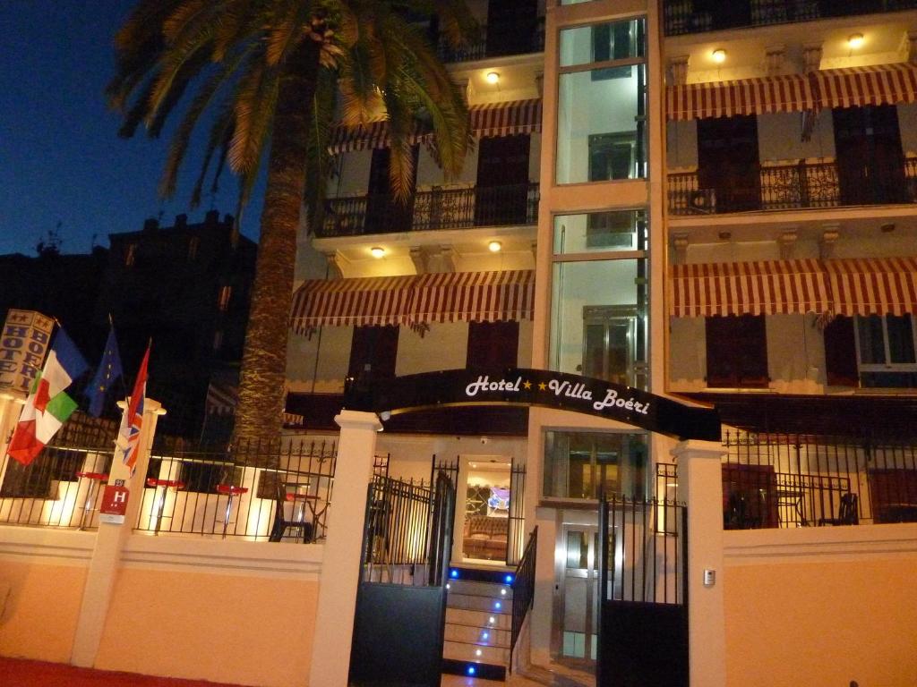 a building with a palm tree in front of it at Hôtel Villa Boeri in Beausoleil