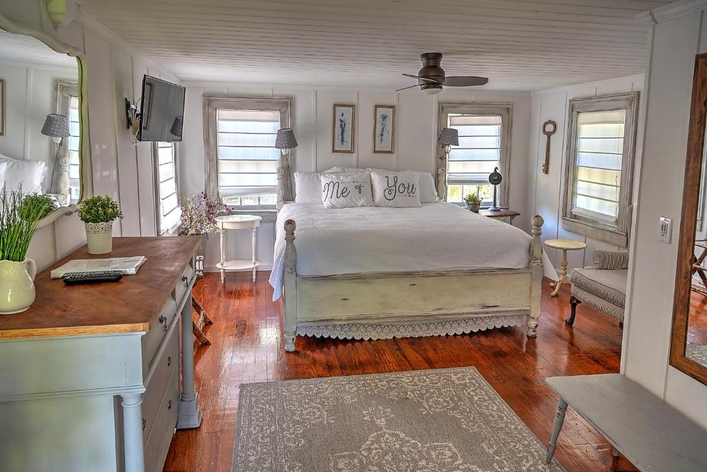 a bedroom with a bed and a desk with a television at Open Gates Bed & Breakfast in Darien