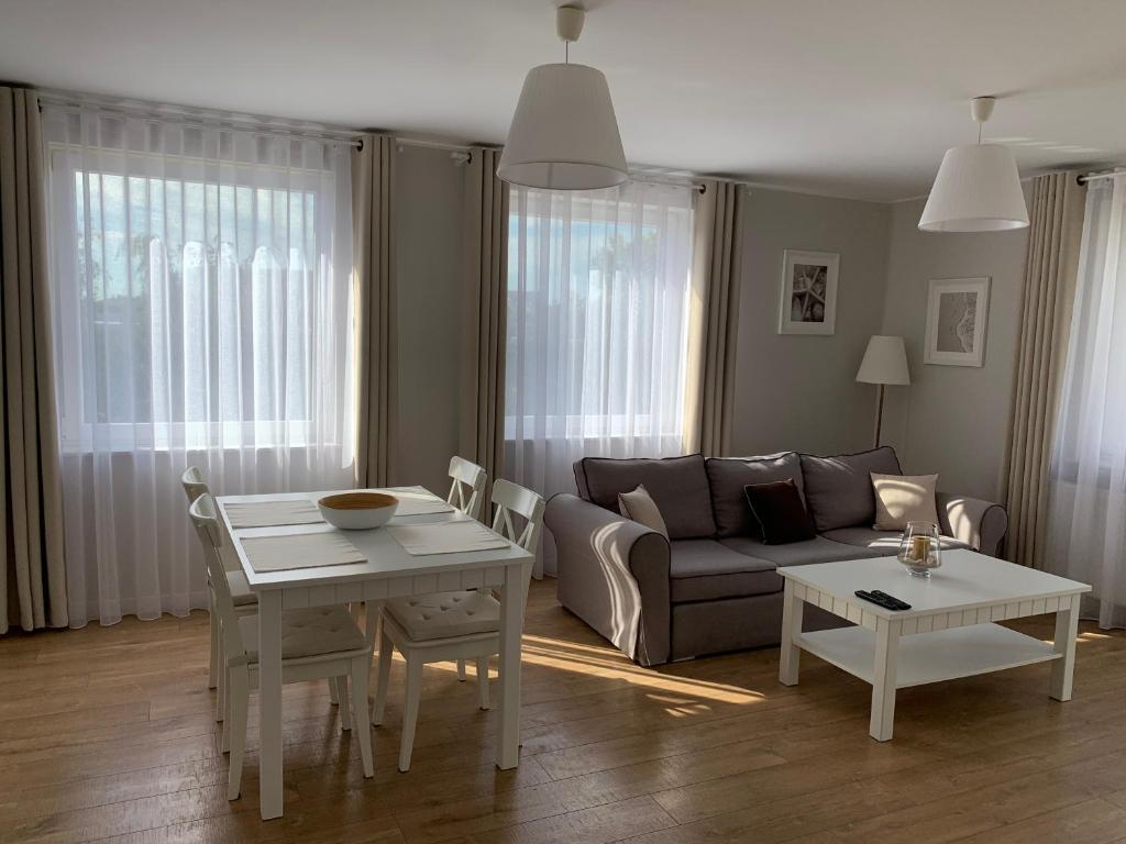 - un salon avec un canapé et une table dans l'établissement Apartament Bliżej Morza, à Kołobrzeg