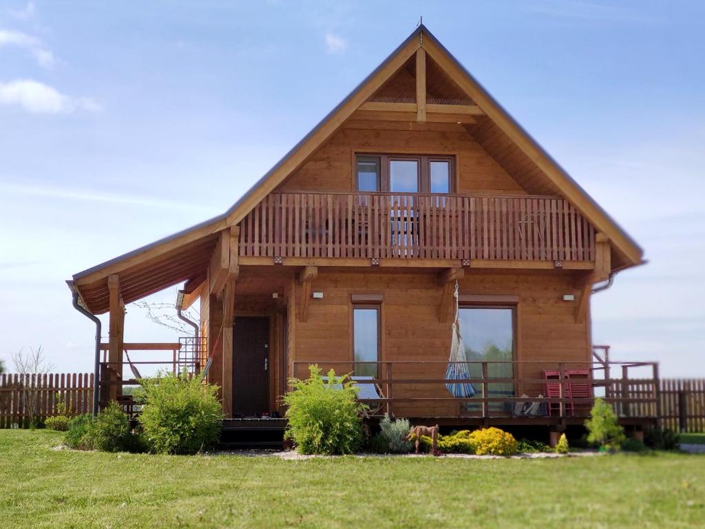 Cabaña de madera con terraza y porche en Domki Sowi Kamień, en Łomnica