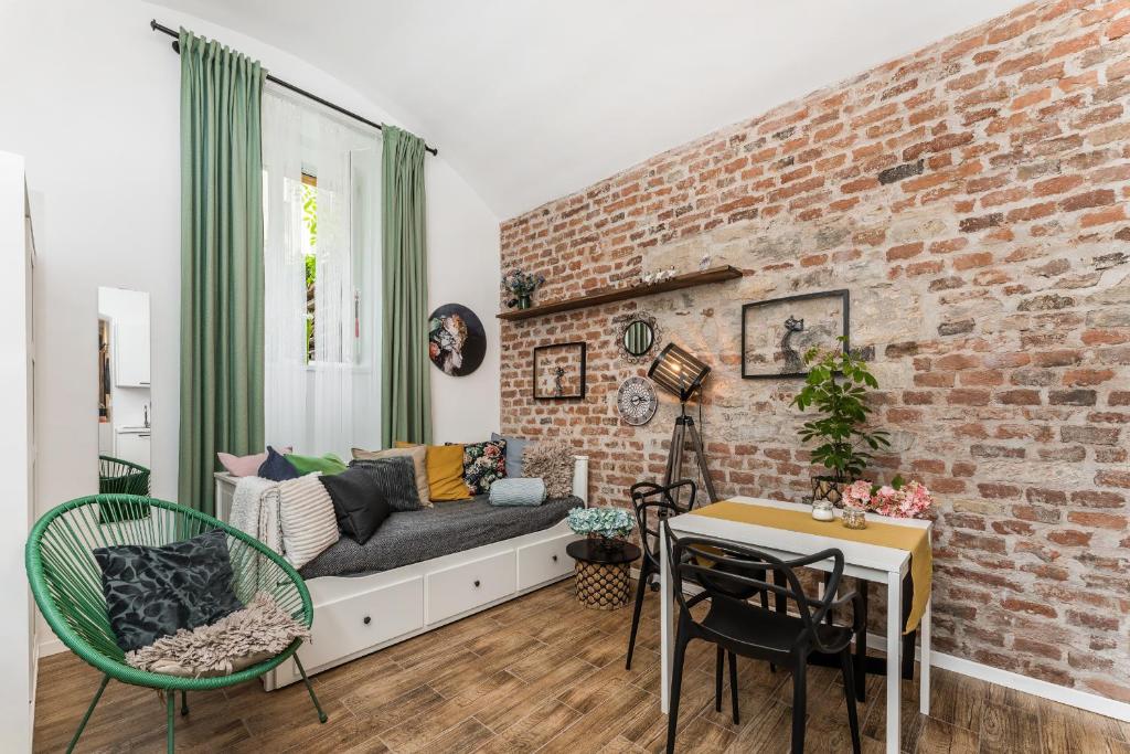 a living room with a brick wall and a couch at Apartmán u Stromovky nedaleko centra in Prague