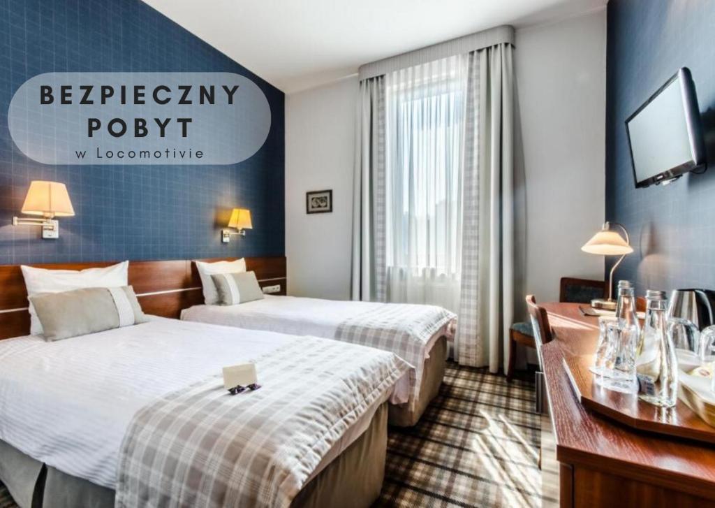 a hotel room with two beds and a television at Locomotiva in Lublin