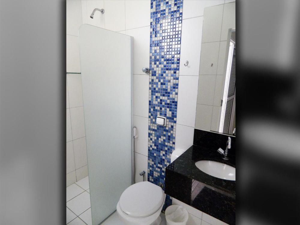 a bathroom with a toilet and a sink and a mirror at Hotel Redentor in Santa Vitória