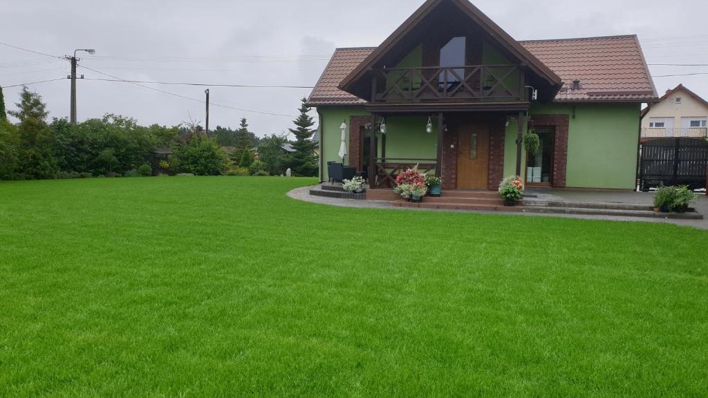 Cekcyn的住宿－Zielona Mila Dom Wakacyjny，前面有大草坪的房子