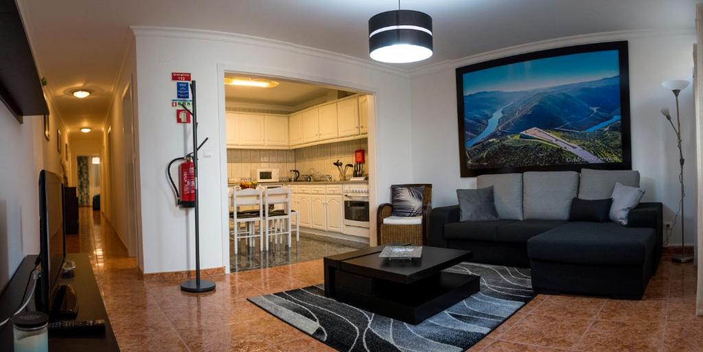 a living room with a couch and a kitchen at Casa da Rocha - Alojamento Local in Vila Nova de Foz Coa