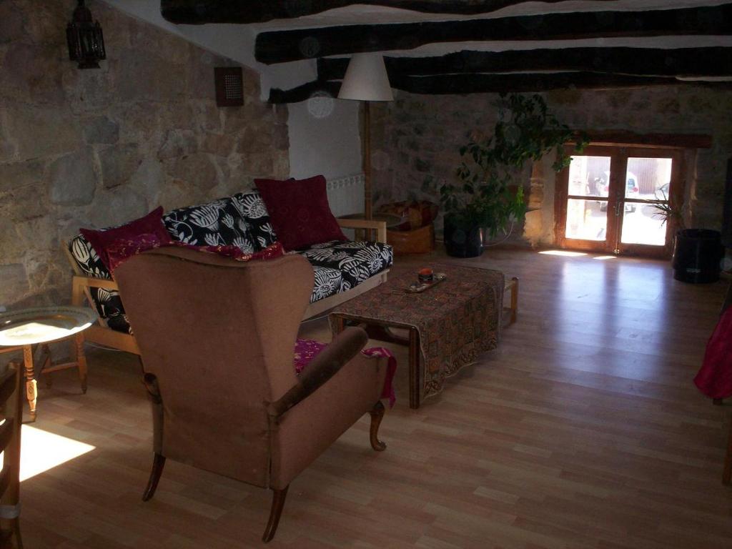 a living room with a couch and a chair at Rural Horizons on La Ruta del Cister in Forés
