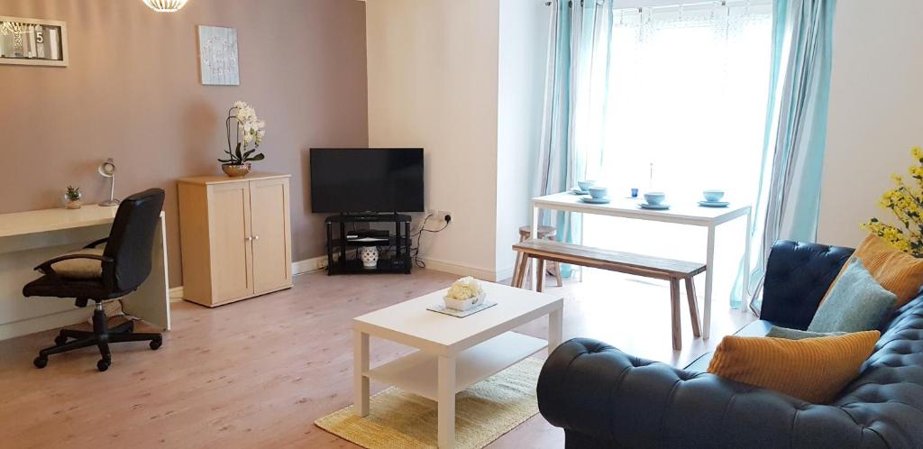 sala de estar con sofá y TV en Sun Gardens Serviced Apartment, en Thornaby on Tees