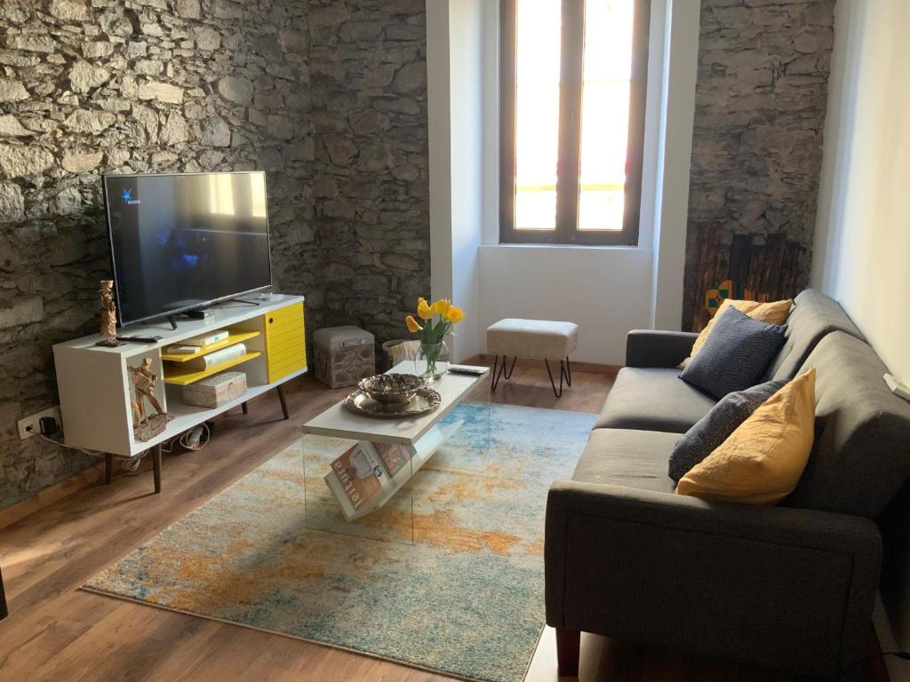 een woonkamer met een bank en een tv bij Techas City Center Luxurious Studio in Praia