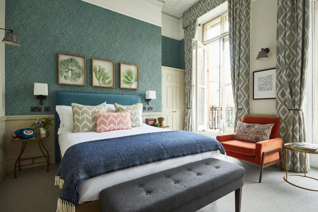 Lime Tree Hotel في لندن: غرفة نوم بسرير كبير وكرسي