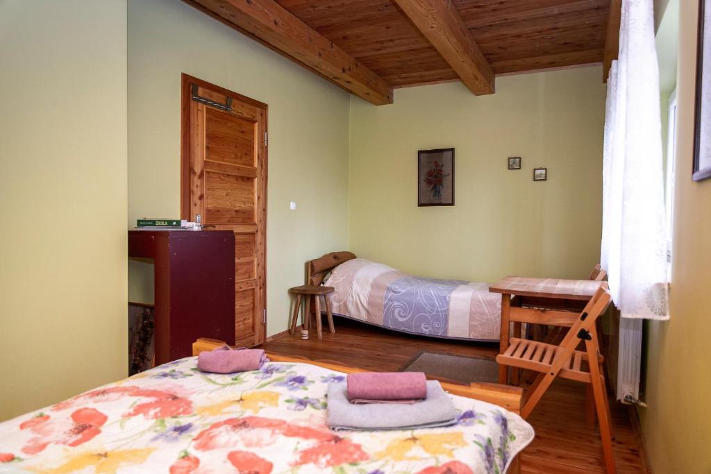 Un dormitorio con 2 camas y un escritorio en una habitación. en Bieszczadzki Kąt, en Lesko